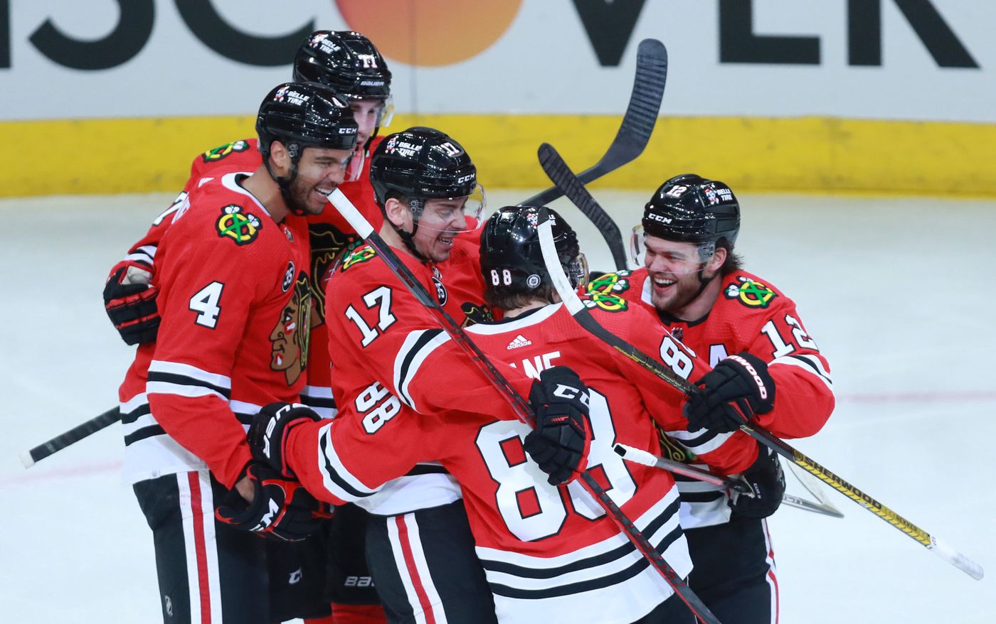 Blackhawks left wing Alex DeBrincat (right) celebrates with his teammates after scoring his second goal of the third period.