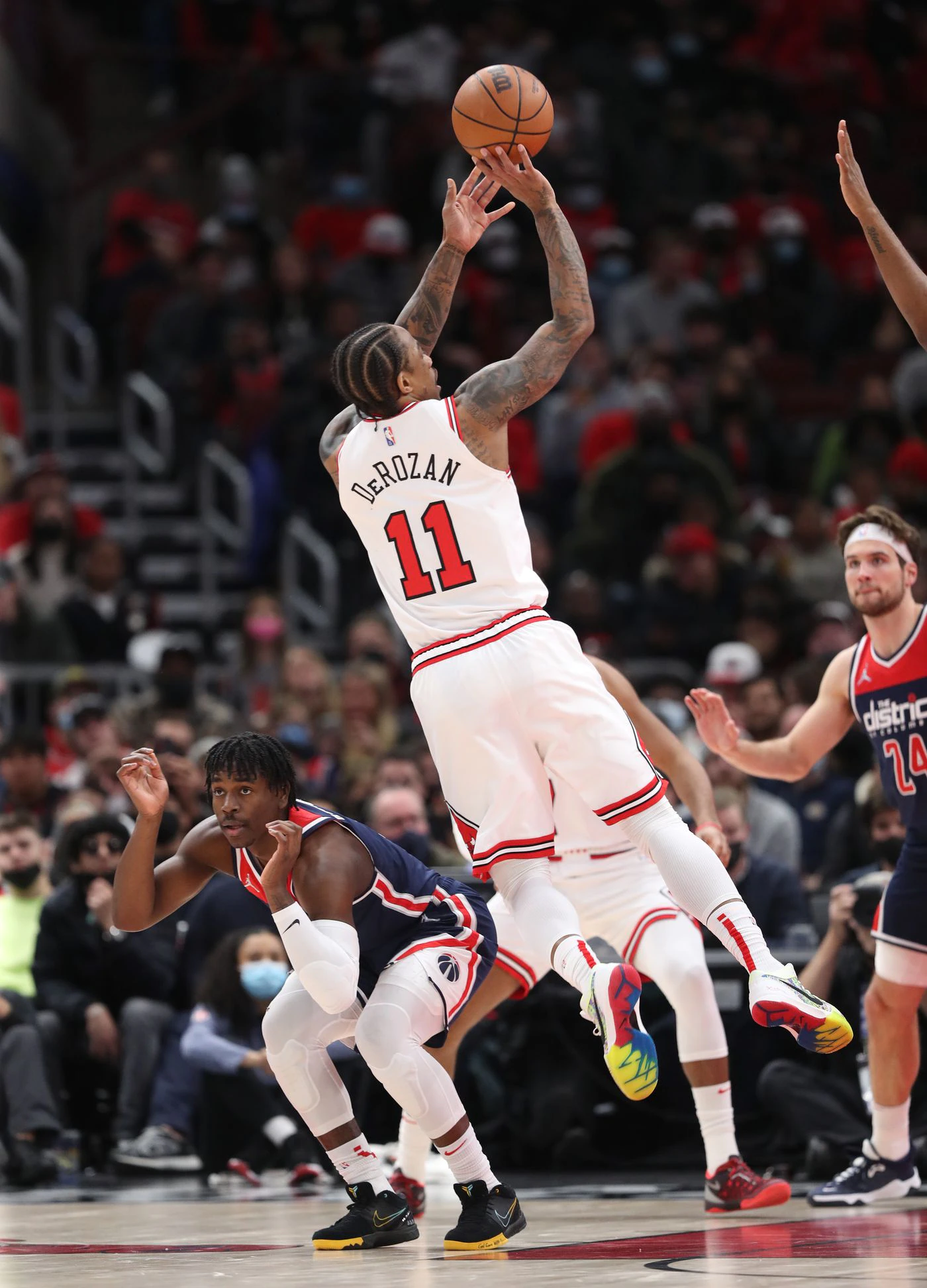Washington Wizards guard Aaron Holiday (4) ducks as Chicago Bulls forward DeMar DeRozan (11) makes a shot attempt in the fourth quarter at United Center on Jan. 7, 2022, in Chicago.
