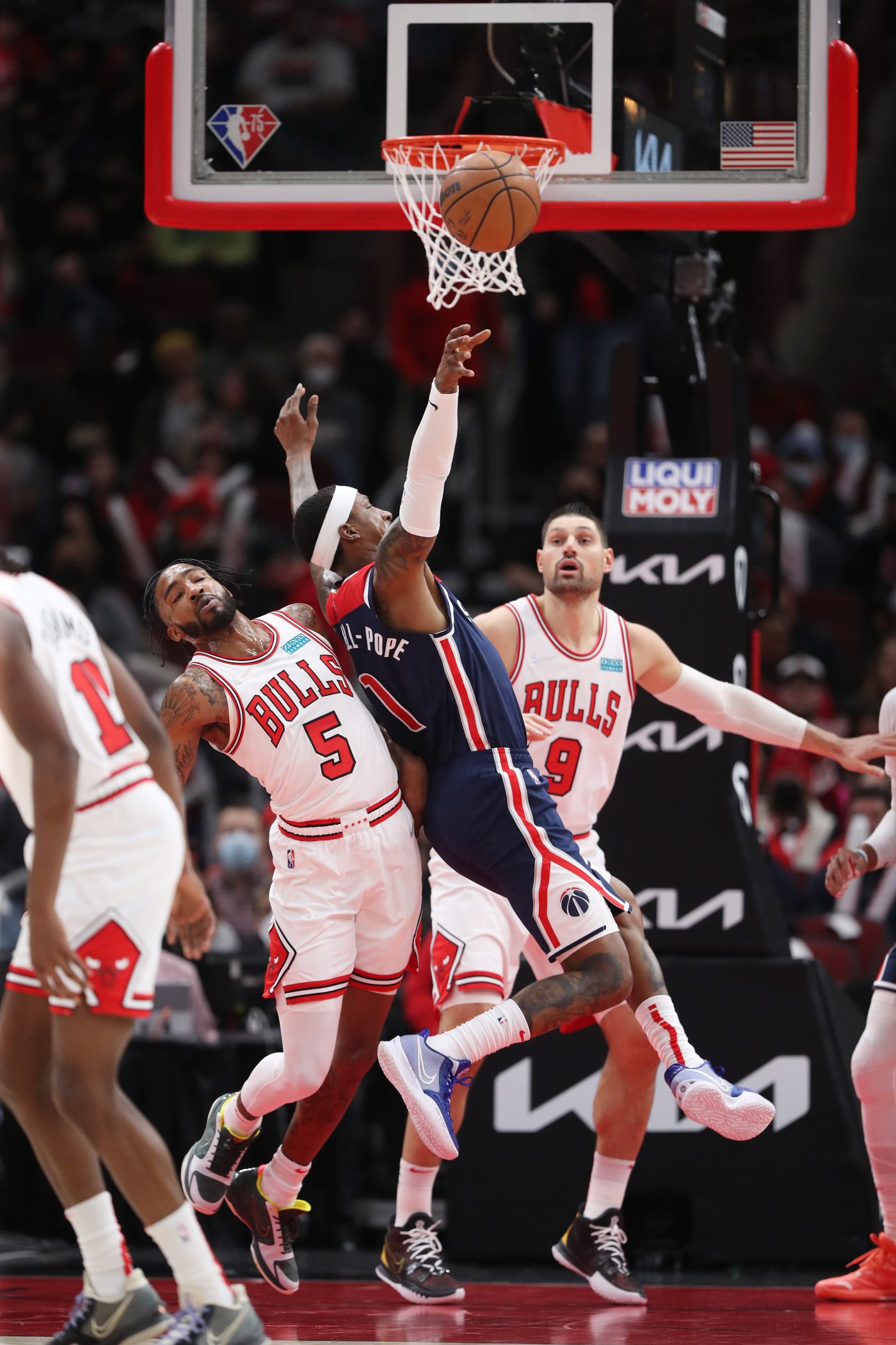 Chicago Bulls forward Derrick Jones Jr. (5) fouls Washington Wizards guard Kentavious Caldwell-Pope (1) in the first quarter at United Center on Jan. 7, 2022, in Chicago.