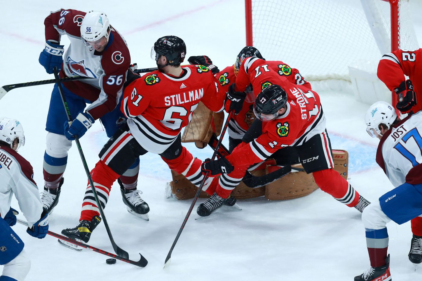 Blackhawks center Dylan Strome (17) and defenseman Riley Stillman (61) try to clear the puck in the first period.