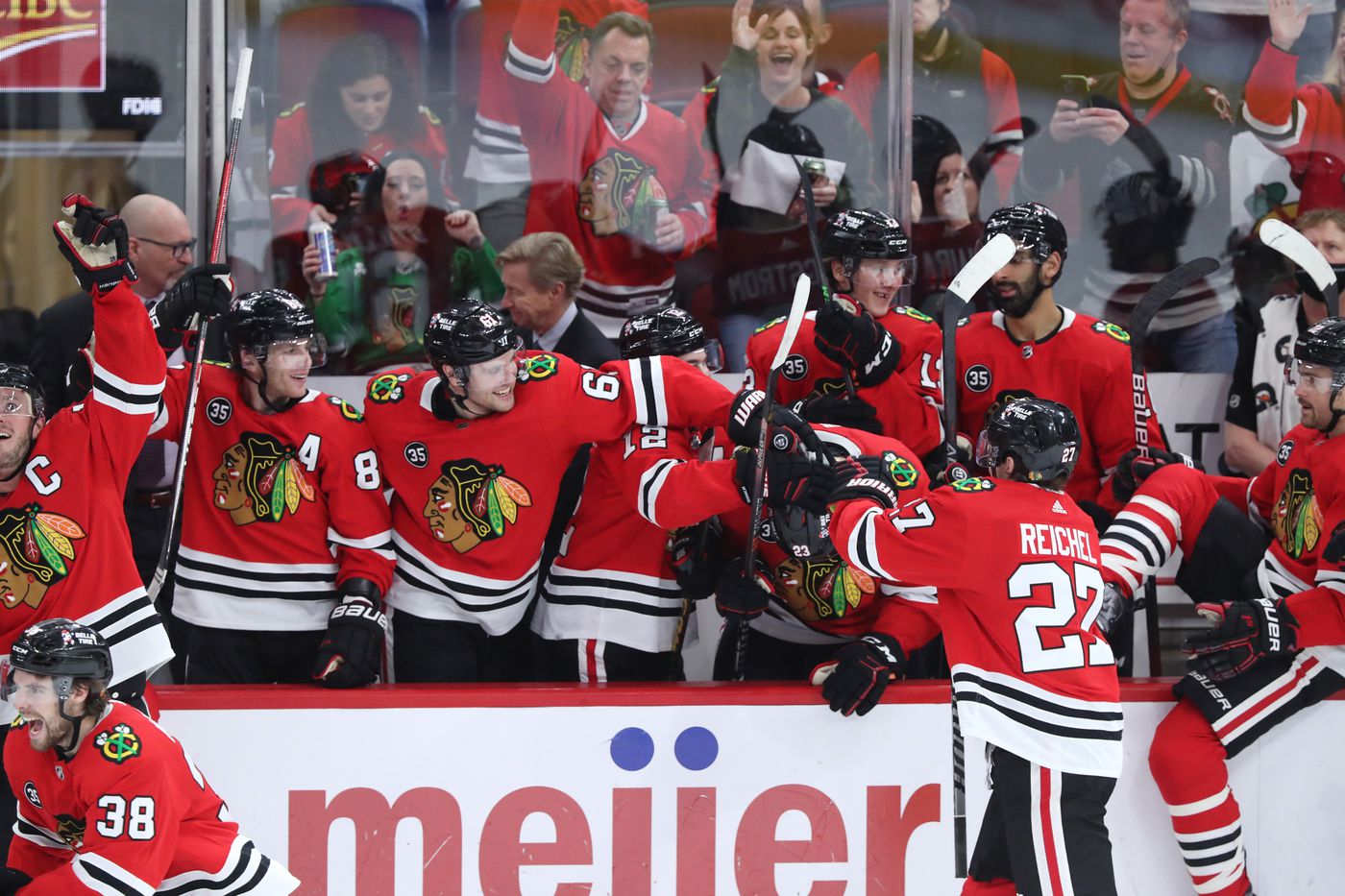 Chicago Blackhawks players congratulate center Philipp Kurashev (23) after an officials review ruled his goal was good for a 3-2 overtime win over the Montreal Canadiens at United Center on Jan. 13, 2022, in Chicago.