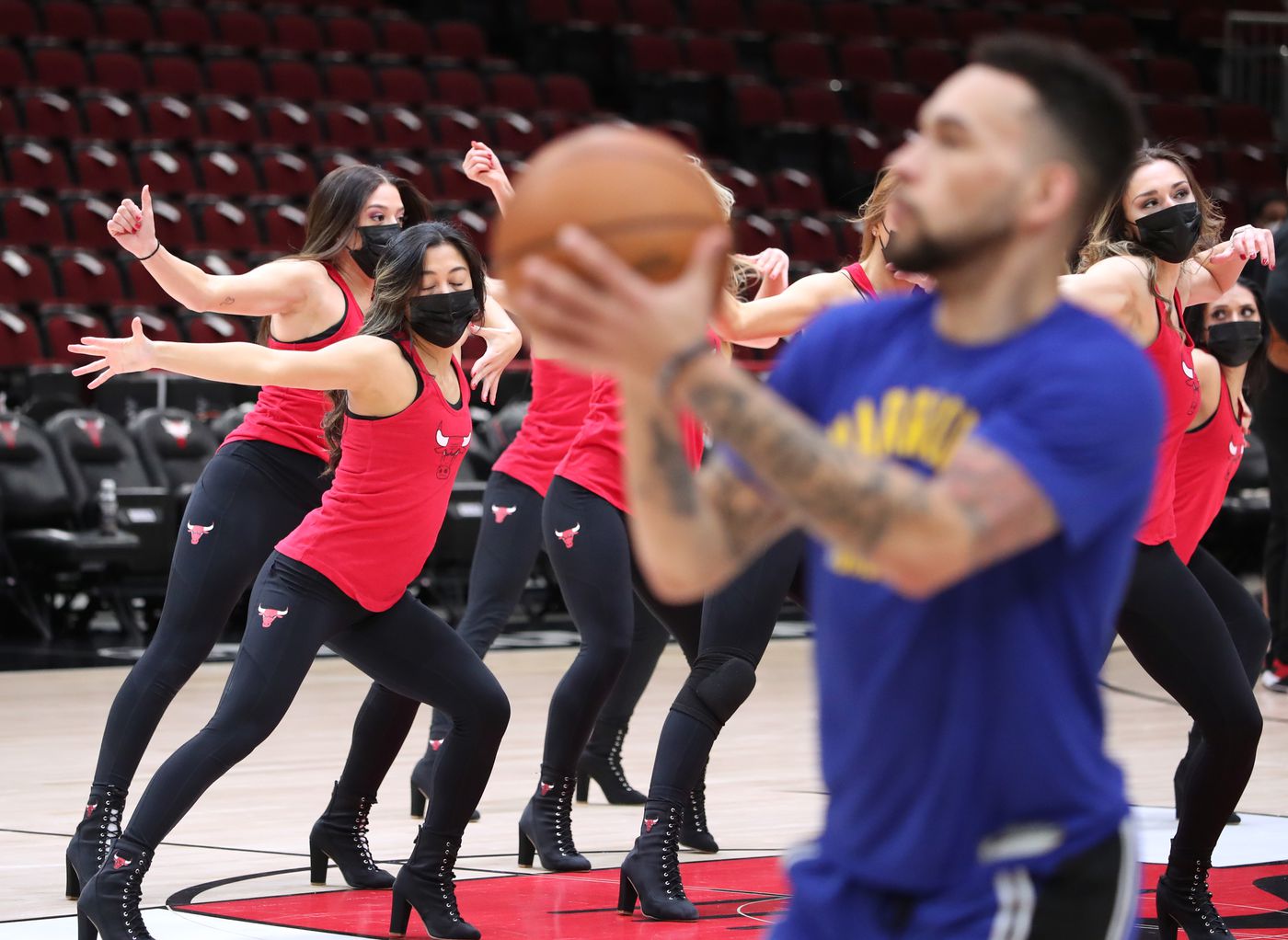 Chicago Luvabulls dancers rehearse as Golden State Warriors guard Chris Chiozza (2) warms up before a game between the Warriors and Chicago Bulls at United Center on Jan. 14, 2022, in Chicago.