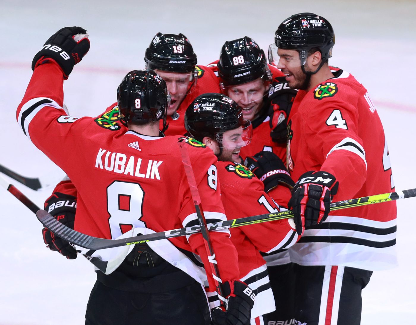Blackhawks left wing Alex DeBrincat (center) celebrates with his teammates after scoring a goal in the third period.