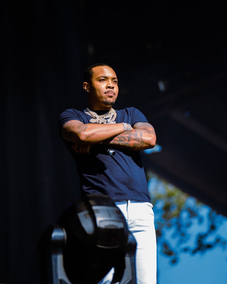 G Herbo stands onstage at Summer Smash in a dark blue T-shirt and chains, with his arms folded over his chest