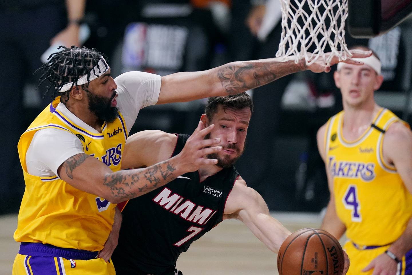 The Heat's Goran Dragic (7) drives to the basket against Anthony Davis, left, while the Lakers' Alex Caruso looks on during Game 1 of the NBA Finals on Sept. 30, 2020, in Lake Buena Vista, Fla.