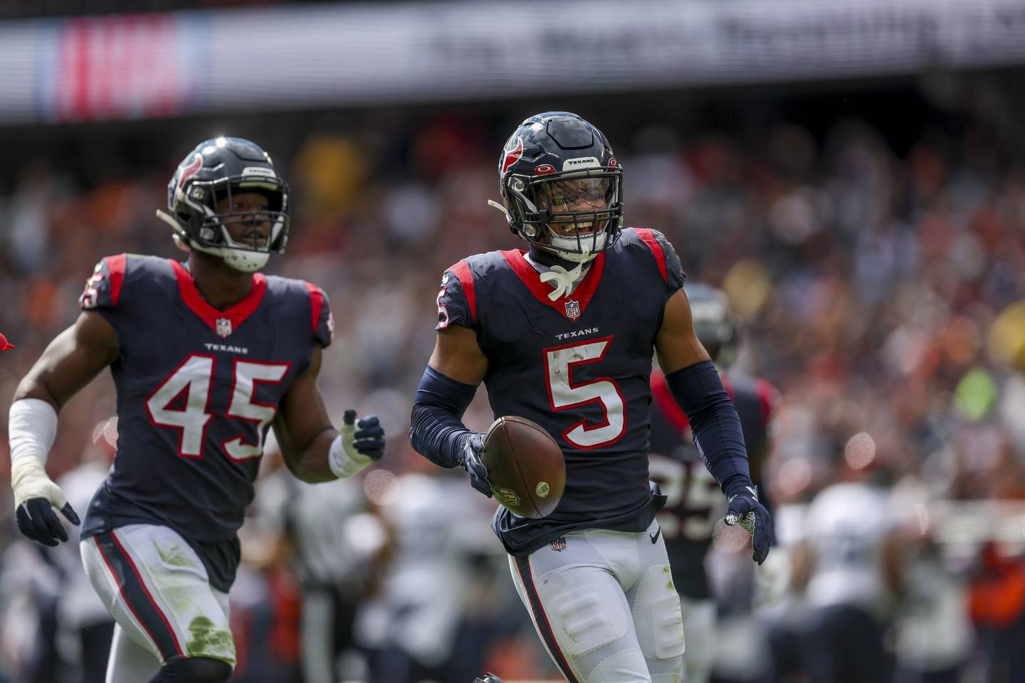 Texans safety Jalen Pitre (5) runs down the field while celebrating after making an interception during the first quarter against the Bears at on Sunday at Soldier Field. 