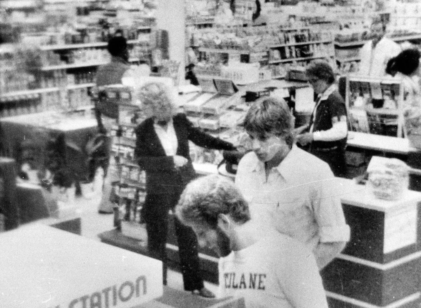 A still from a drugstore camera shows Paula Prince, center in suit, as she buys a bottle of tainted Tylenol in 1982 at the Walgreens near her home in Chicago.