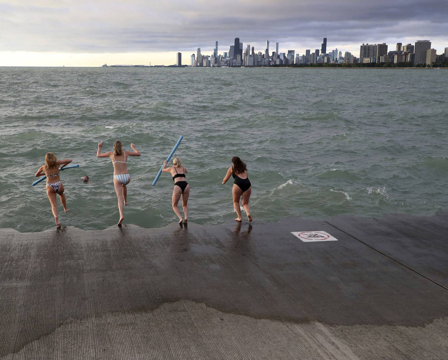 Swimmers jump in Lake Michigan as part of the Friday Morning Swim Club at Montrose Harbor in Chicago. Hundreds of people gather on Fridays and jump in together. 