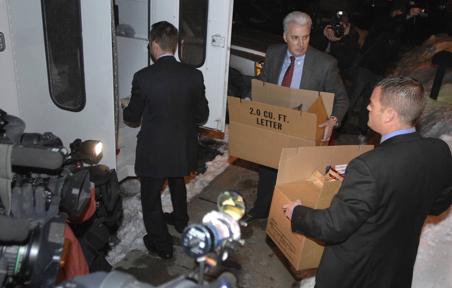 FBI agents carry out boxes after searching the apartment of James Lewis in Cambridge, Massachusetts, in 2009. Documents reviewed by the Tribune show investigators found a four-page, handwritten timeline of the Lewises’ movements in the weeks before and after the Tylenol killings.