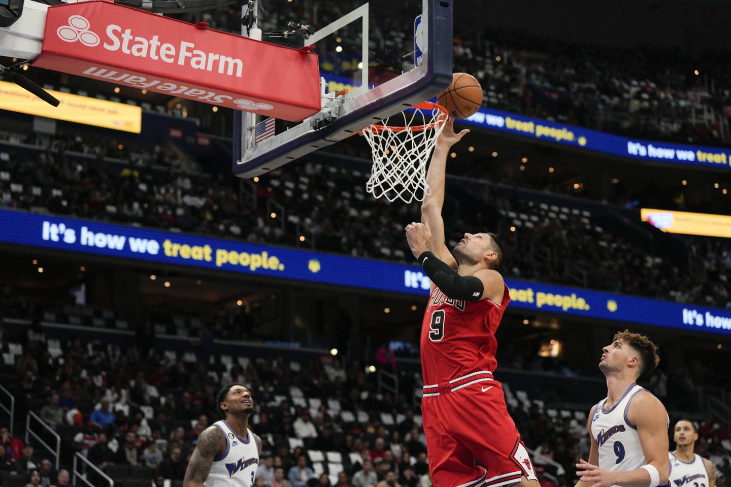 Bulls center Nikola Vučević (9) scores against Wizards guard Bradley Beal, left, and forward Deni Avdija during the first half Friday in Washington. (AP Photo/Jess Rapfogel)