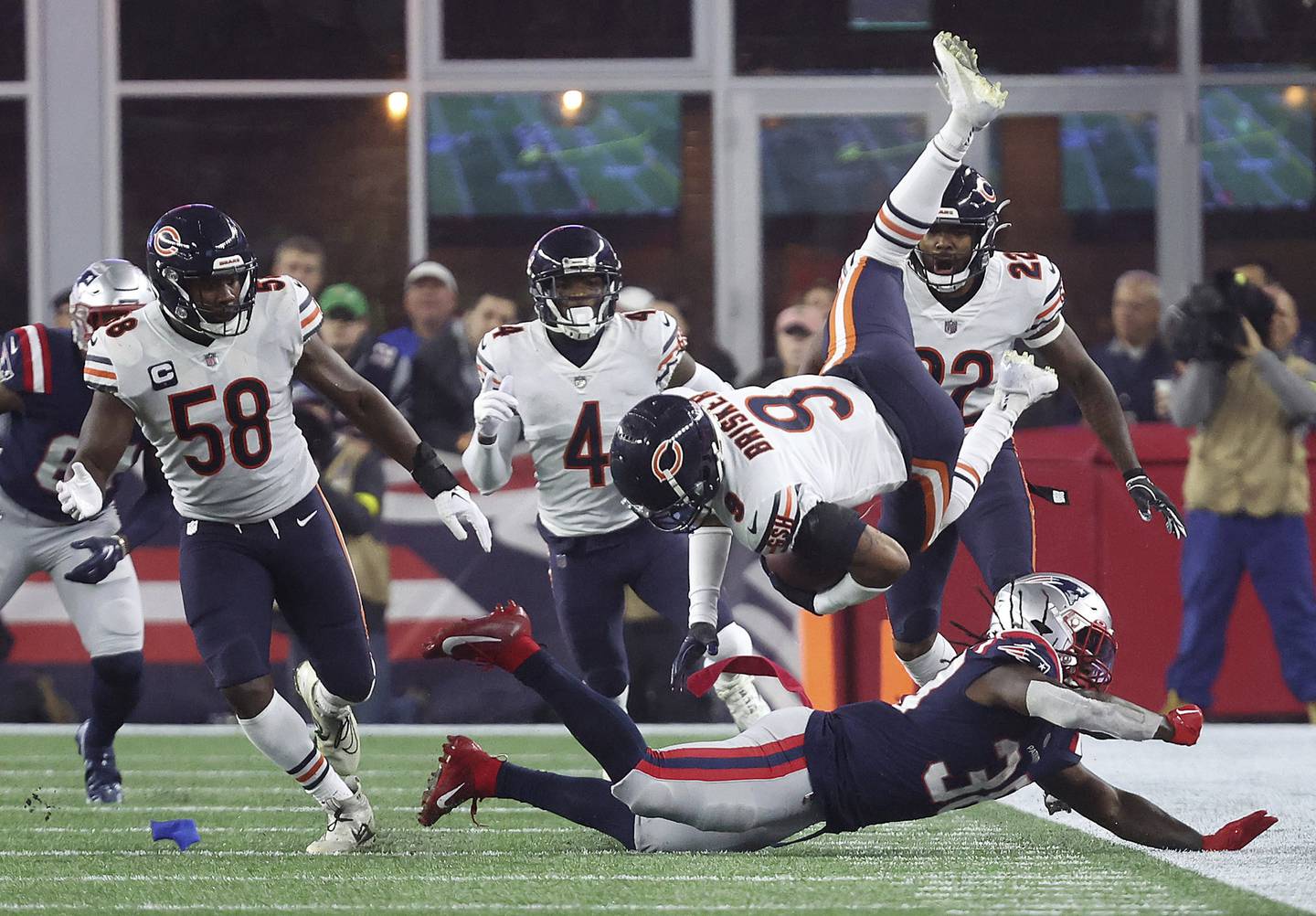 Bears safety Jaquan Brisker flips through air as he is tackled following his interception in the second quarter against the Patriots at Gillette Stadium on Oct. 24, 2022.