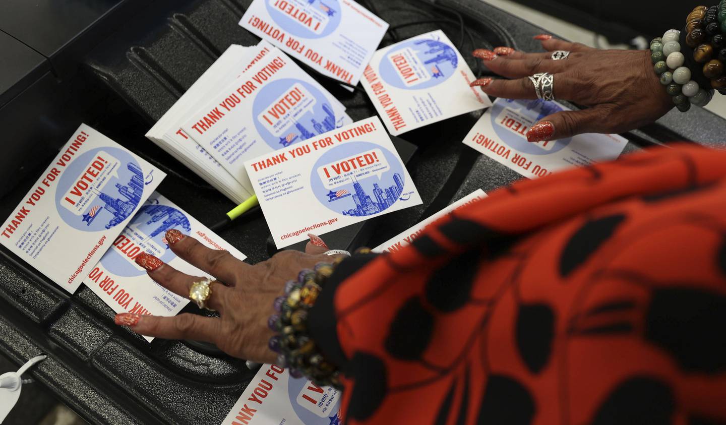 Election official Cynthia Webb puts out thank you for voting stickers during the first day of early voting at the Chicago Board of Elections Super Site on Oct. 7, 2022. 