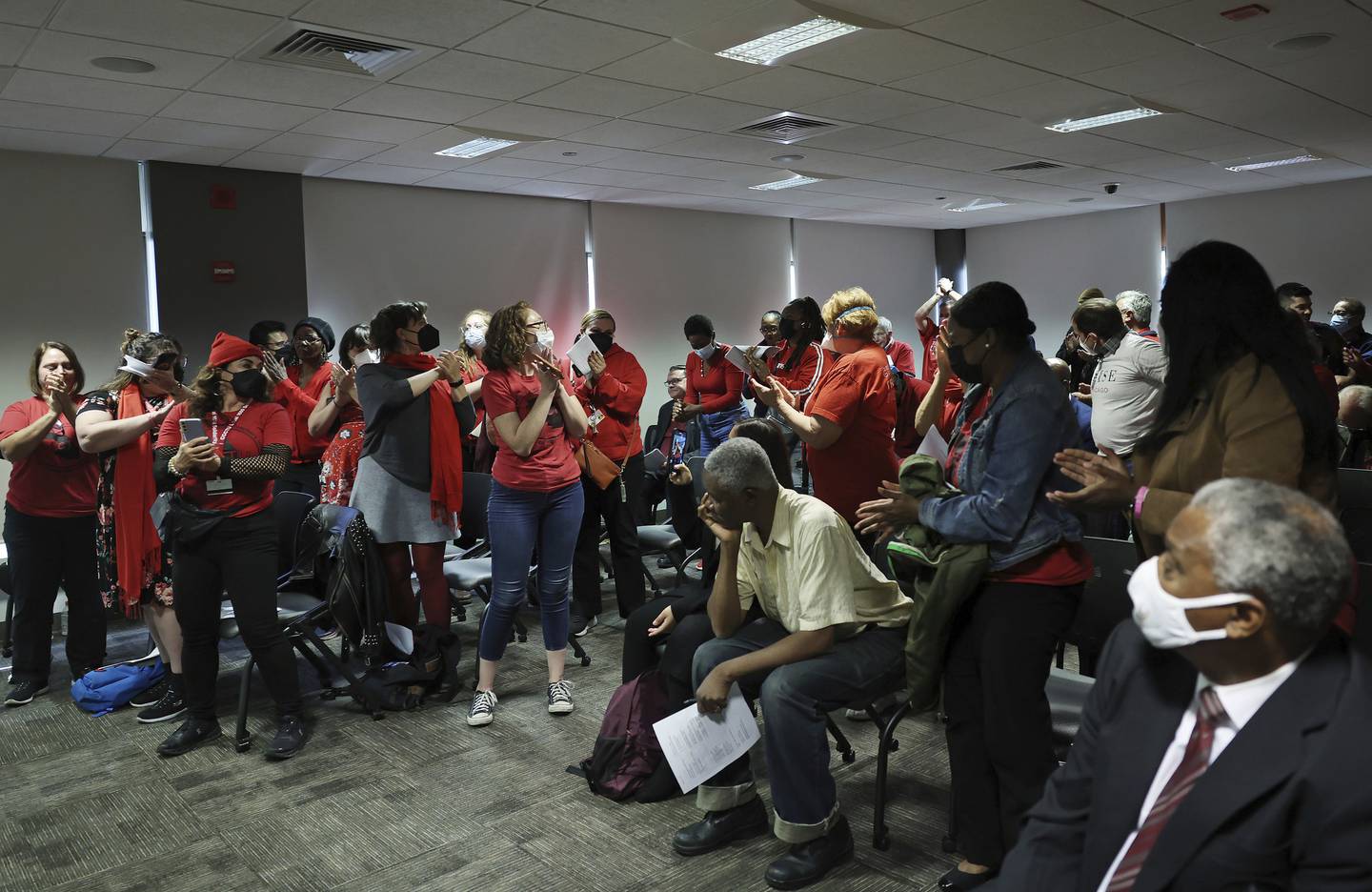Cook County College Teachers Union Local 1600 members and supporters applaud its president, Tony Johnston, background center, after he addressed City Colleges of Chicago board members during a meeting at Harold Washington College on Oct. 6. 