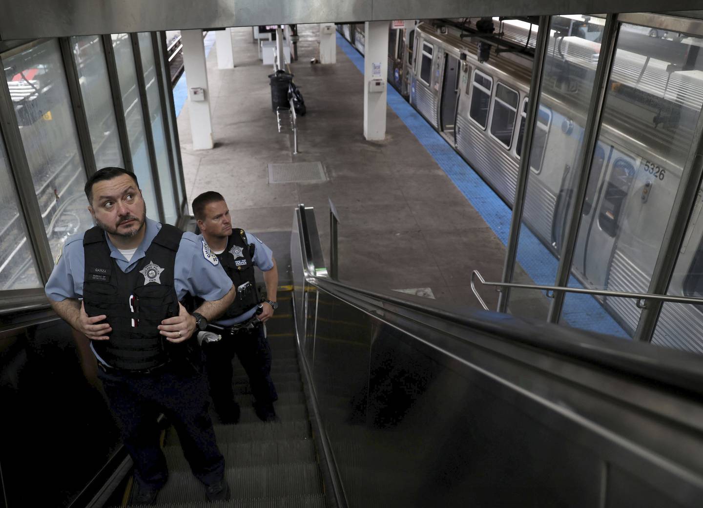 Chicago police officers Manuel Garza, left, and Paul Lauber patrol the 95th Street Red Line CTA station on Aug. 8, 2022.
