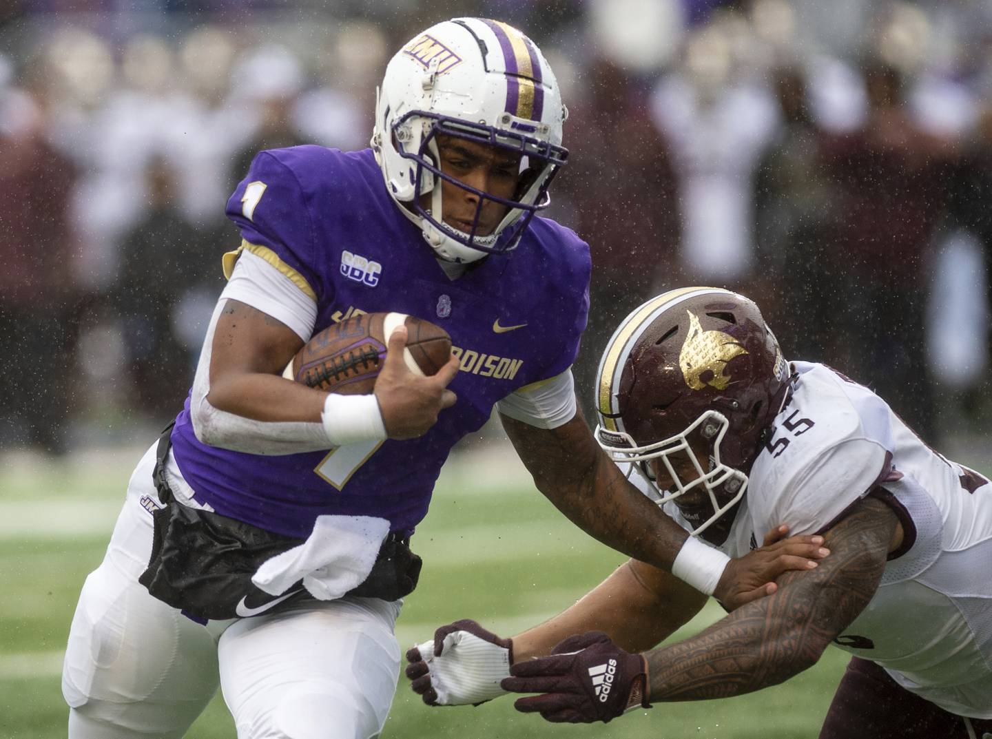 James Madison quarterback Todd Centeio (1) fights off Texas State linebacker Sione Tupou during a game Saturday.