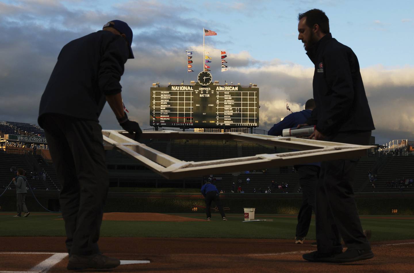Grounds crew workers prepare the batter's box for a game on Sept. 27, 2022.