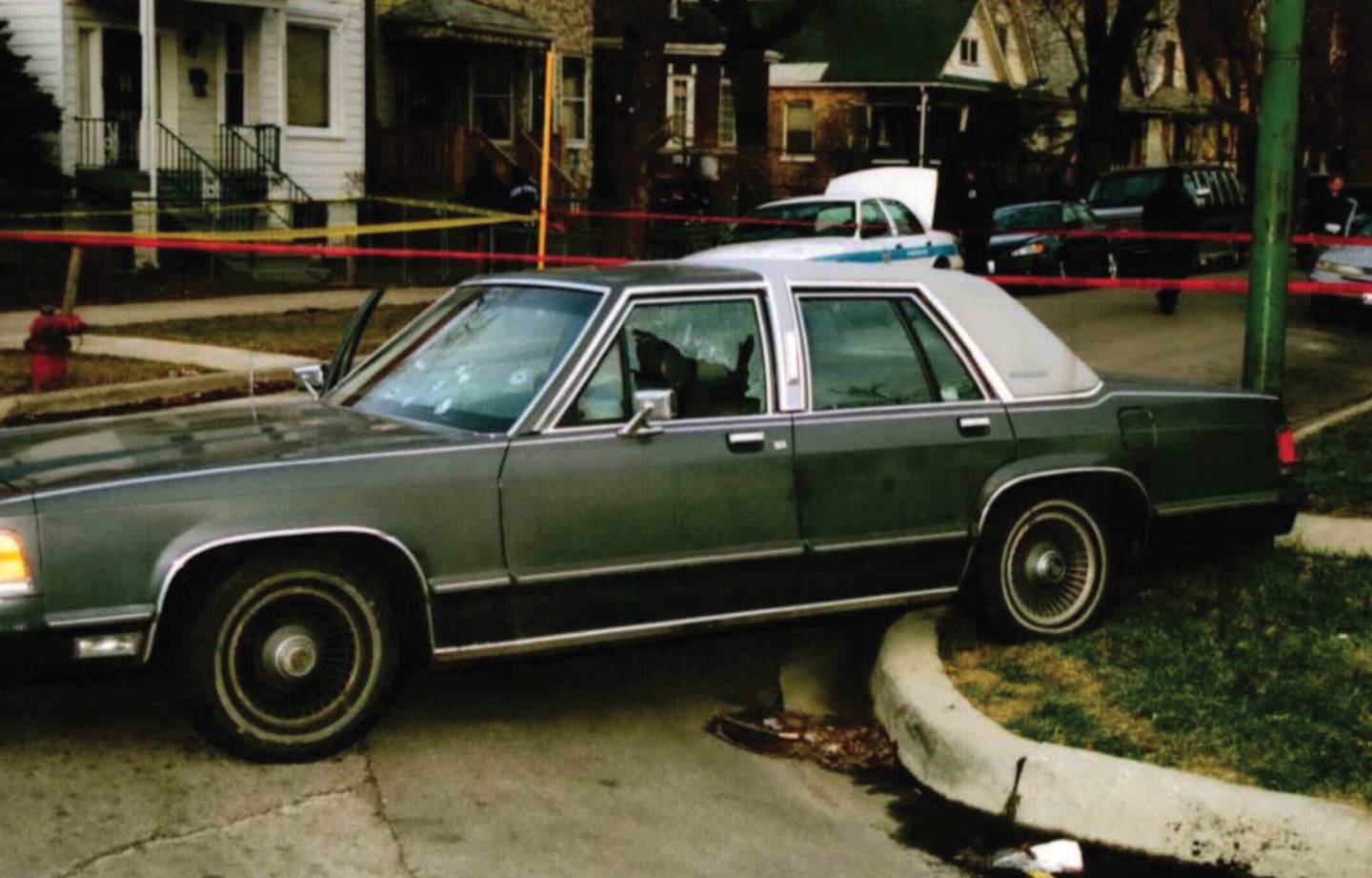 A bullet-riddled car sits at the intersection of Hubbard Street and Lamon Avenue, where 21-year-old Ernest "Pee Wee" Moore was slain on Dec. 23, 2002, allegedly by members of the Wicked Town gang. 
