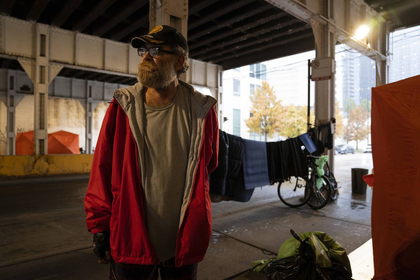 Joseph Wisniewski poses for a portrait near the ice-fishing shelter he is staying in under the Metra bridge. Wisniewski has been unhoused since July.