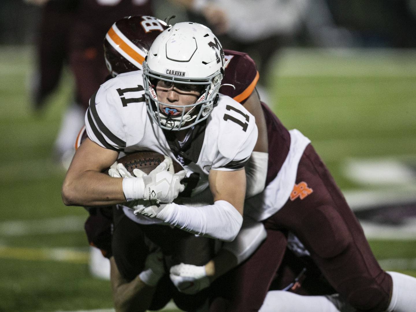 Mount Carmel's Denny Furlong (11) gets tackled after making a catch against Brother Rice during a CCL/ESCC Blue game in Chicago on Friday, Sept. 30, 2022.