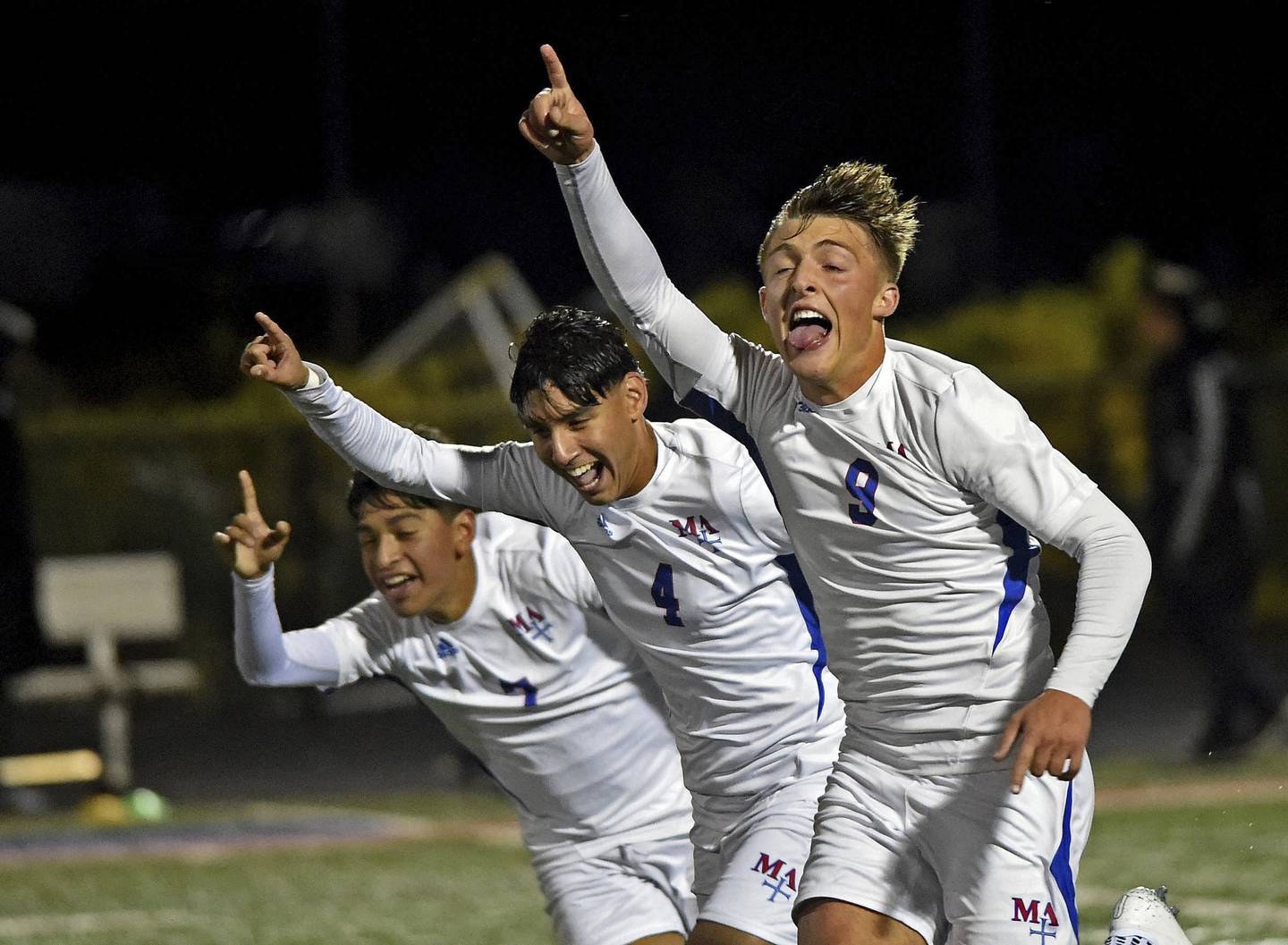 Marmion's Harley Karner celebrates with teammates Diego Tellez and Jordan Peinado after scoring against Rockford Boylan during a Class 2A Glenbard South Sectional semifinal in Glen Ellyn on Tuesday, Oct. 25, 2022.