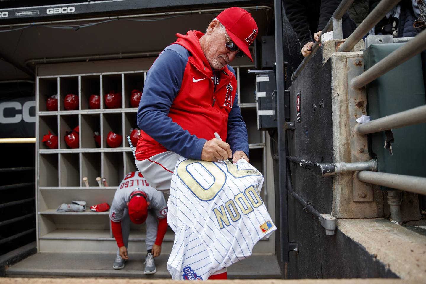 Angels manager Joe Maddon signs his former Cubs jersey before a game against the White Sox at Guaranteed Rate Field on May 1, 2022.