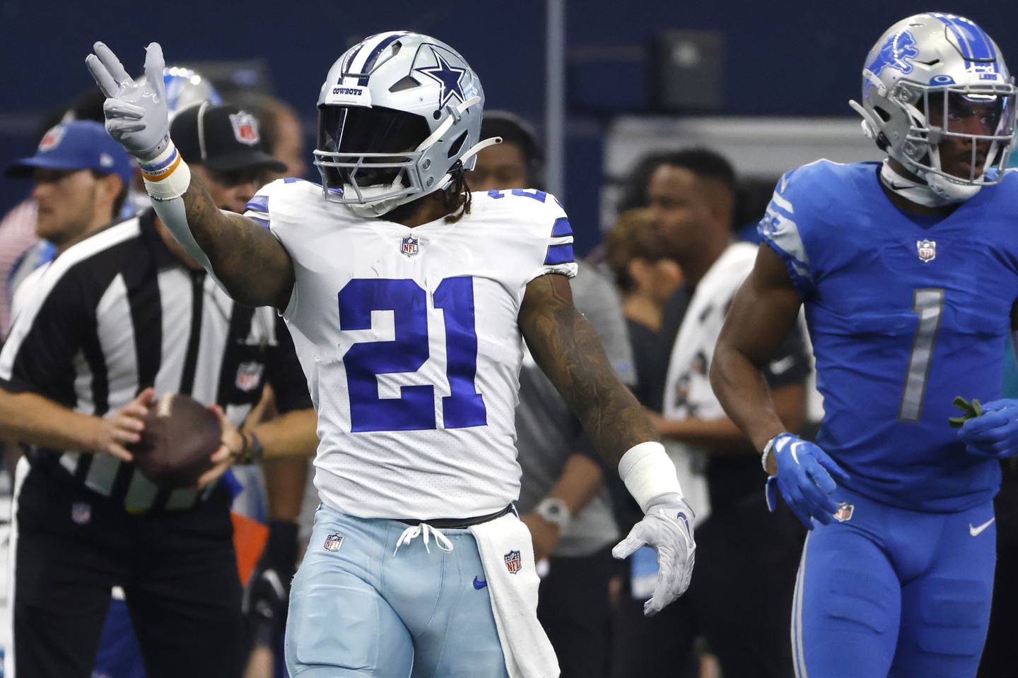 Cowboys running back Ezekiel Elliott signals a first down against the Lions on Sunday in Arlington, Texas. Elliott didn't practice Wednesday and Thursday because of a knee injury. 