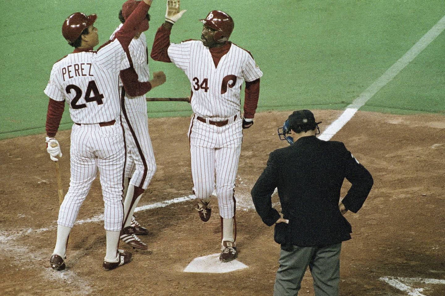 The Phillies' Gary Matthews (34) is congratulated at the plate by teammate Tony Perez (24) after his second-inning solo home run against the Orioles in Game 3 of the World Series on Oct. 14, 1983, in Philadelphia. 