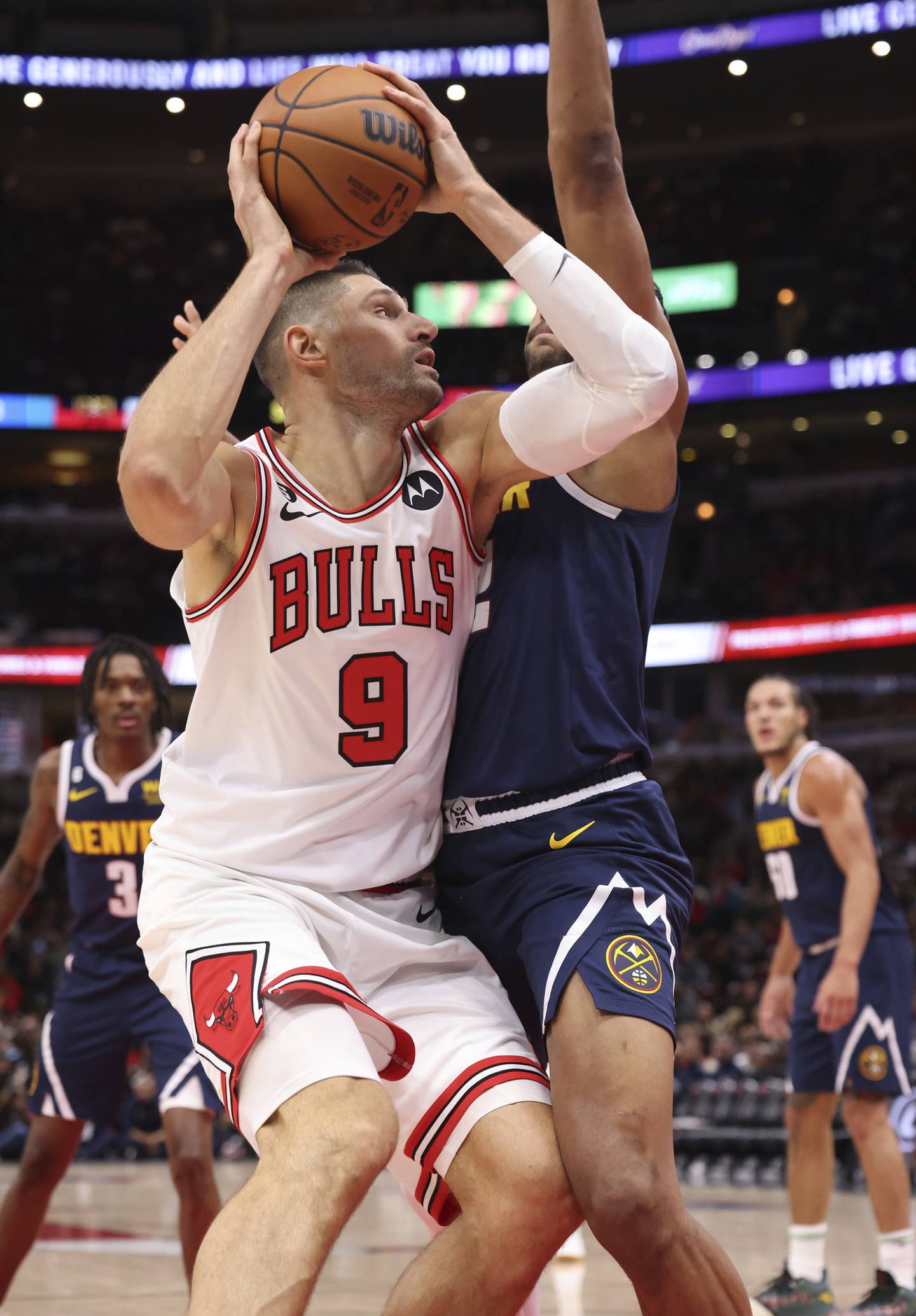 Bulls center Nikola Vučević pivots toward the basket against Nuggets forward Zeke Nnaji in the first quarter of a preseason game on Friday at the United Center. 