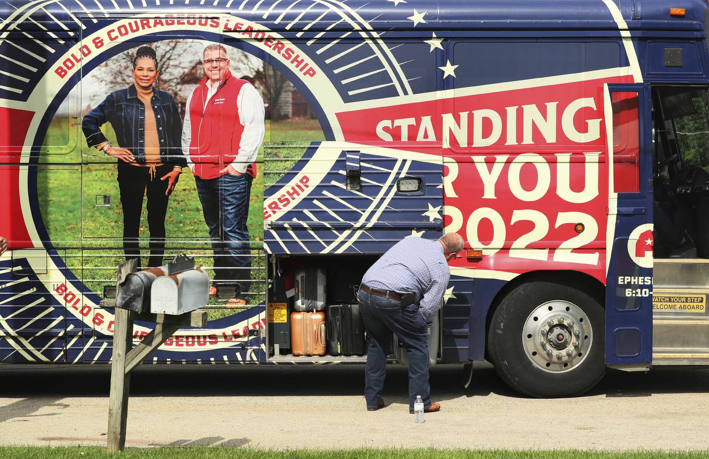 Republican candidate for governor Darren Bailey puts a suitcase on his campaign bus on Sept. 21, 2022, in Mundelein.