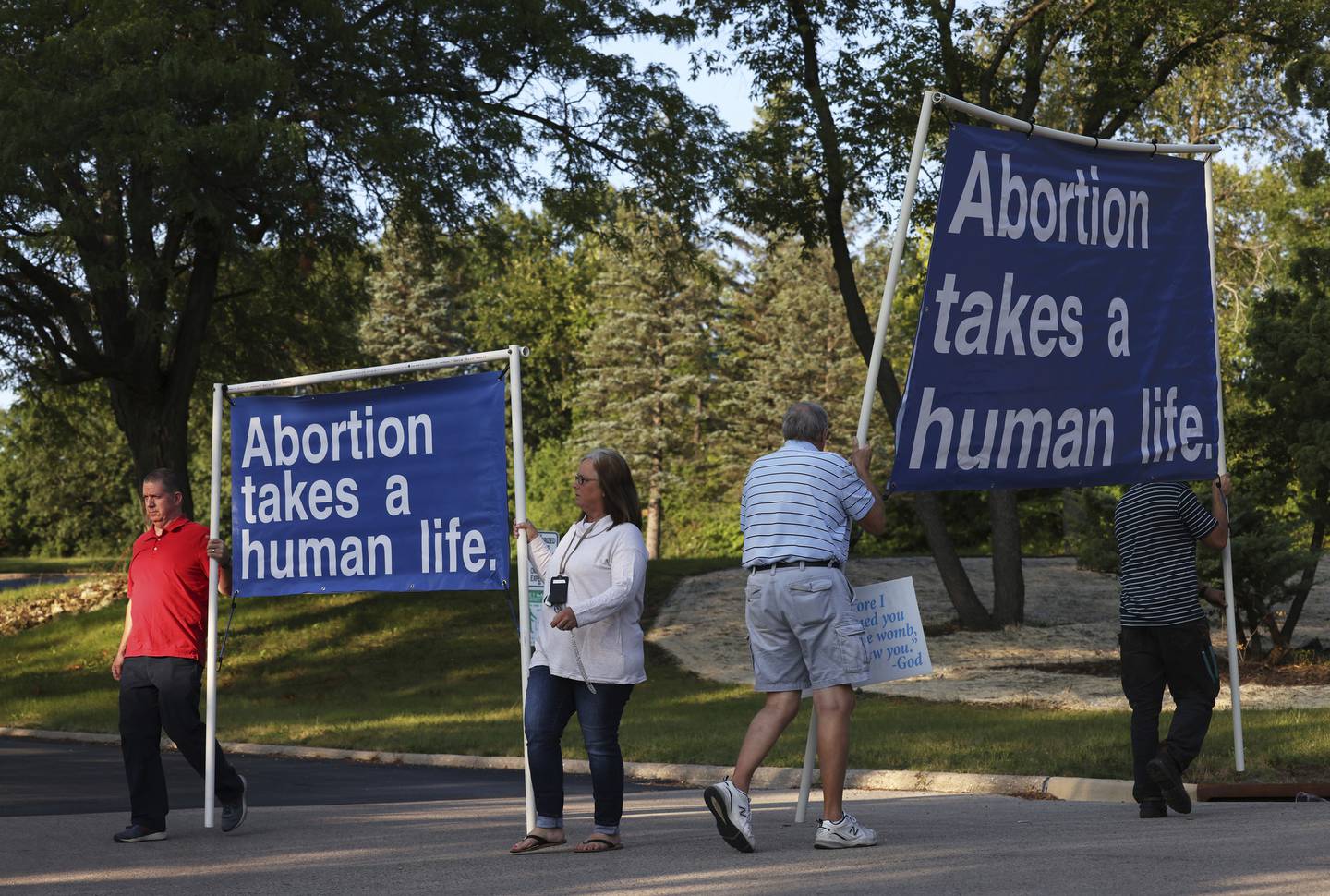 Anti-abortion advocates cross paths while holding signs at the entrance to the Unitarian Universalist Church before a Winnebago County Citizens for Choice forum on Sept. 13, 2022, in Rockford. Eric Sorensen, Democratic candidate for the 17th Congressional District, spoke at the forum. 
