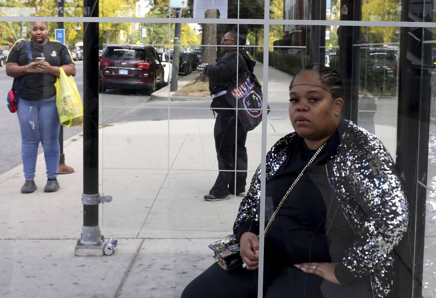 Keisha Moore waits along with others for the notoriously slow and unreliable CTA #4 Cottage Grove bus, in Chicago, on Oct. 6, 2022.   