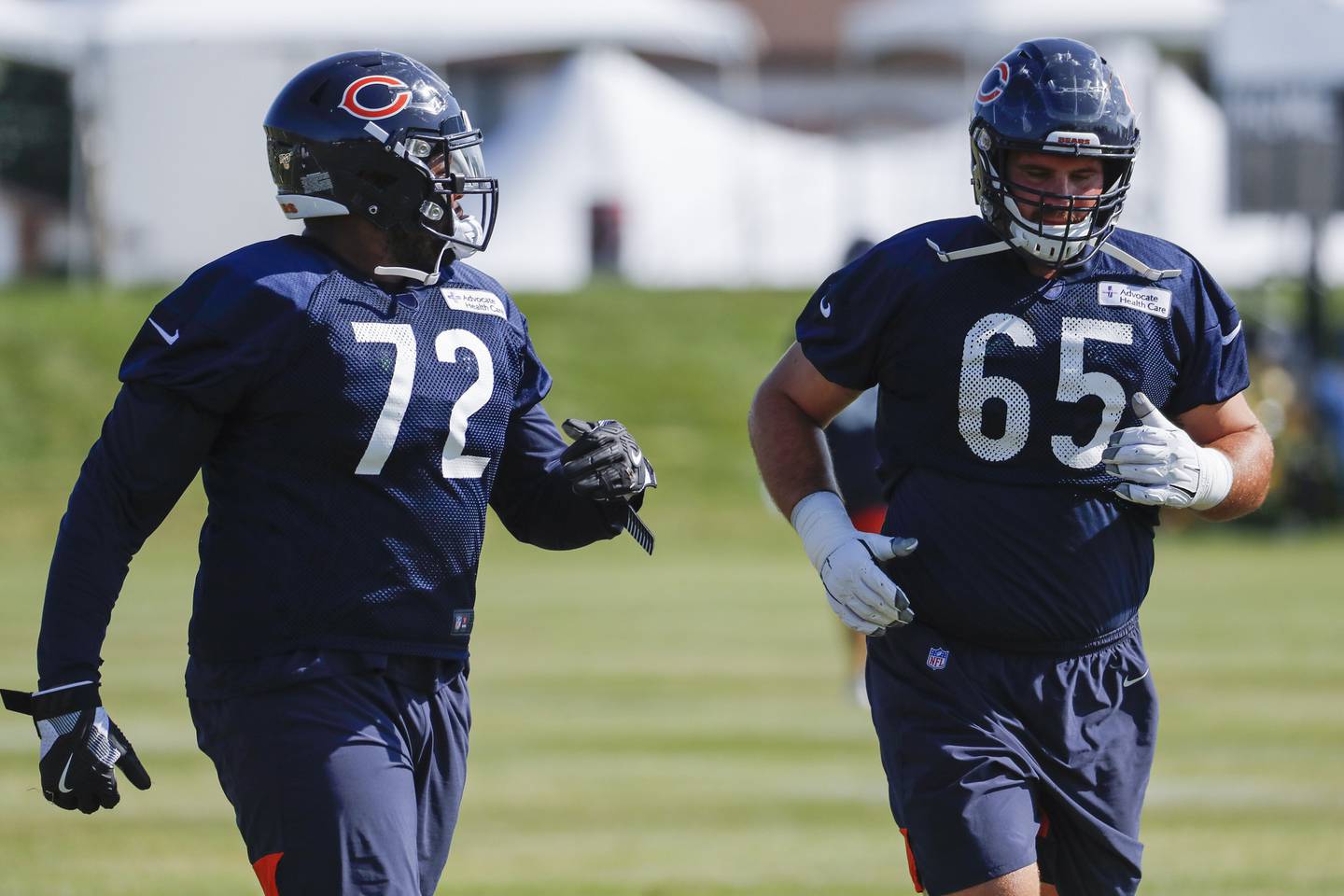 Bears left tackle Charles Leno, left, and center Cody Whitehair stretch and warm up at training camp on July 30, 2019, in Bourbonnais. 