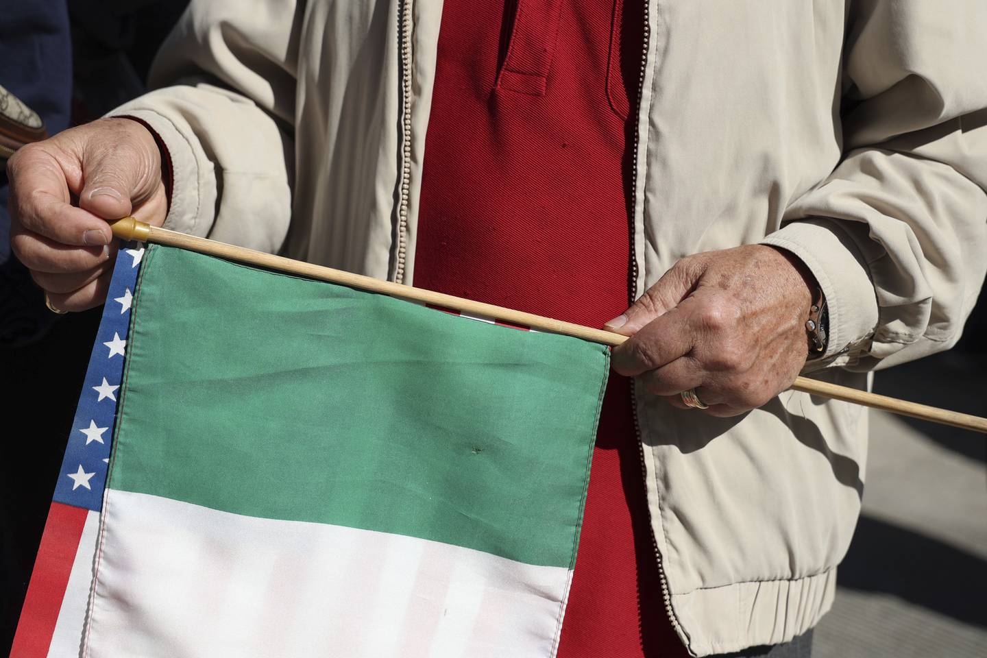 A man holds an American and Italian flag during the Columbus Day Parade on Oct. 10, 2022, in Chicago. 