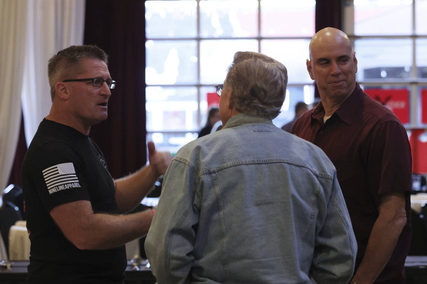 Eric Carlson, left, the GOP candidate for the 1st Congressional District, talks with supporters at a fundraiser for 18th state Senate District Republican candidate Christine Shanahan McGovern, on Sept. 29, 2022, in Merrionette Park.
