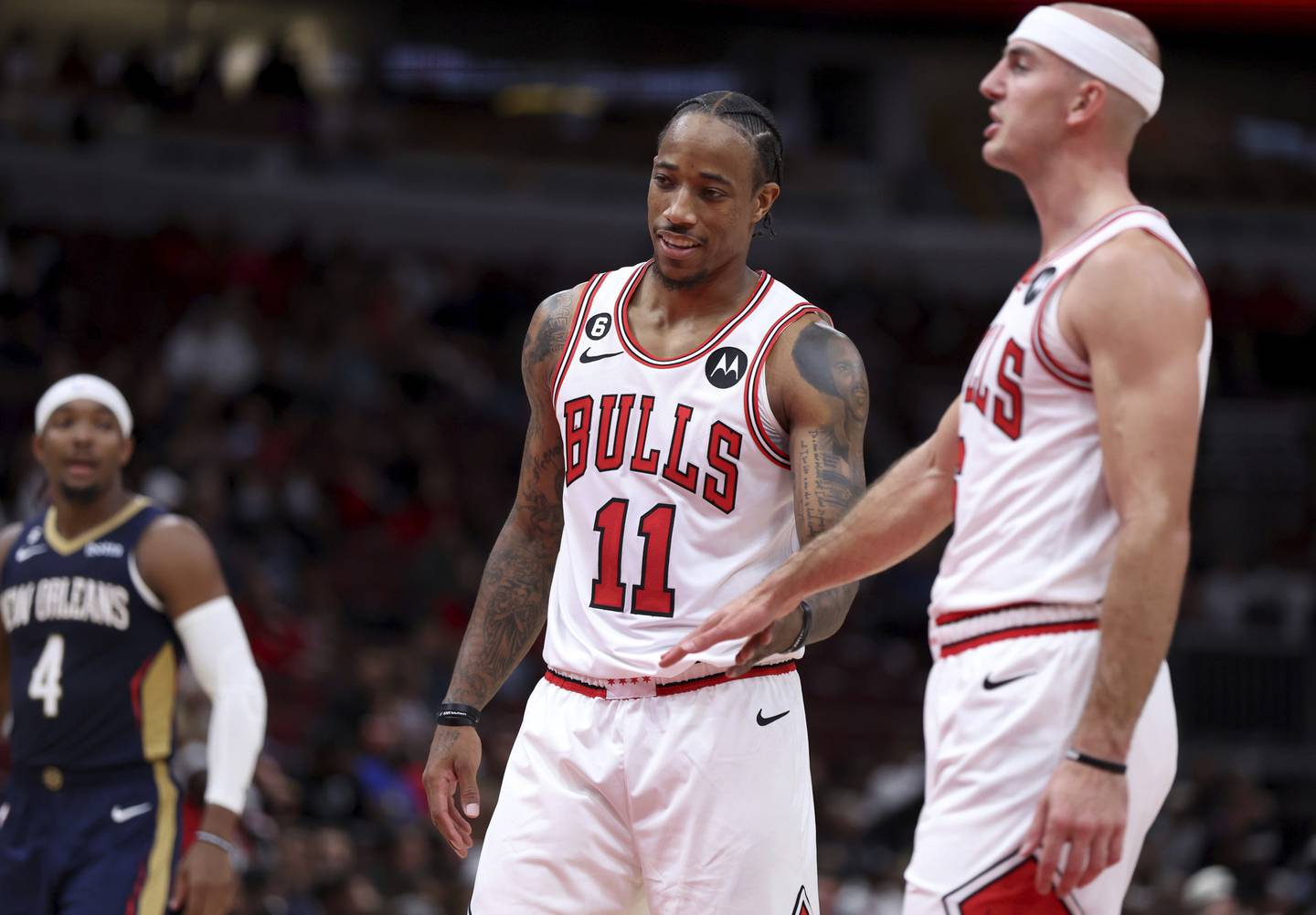 Bulls forward DeMar DeRozan and guard Alex Caruso high-five in the second half of a preseason game against the Pelicans at the United Center on Oct. 4, 2022.