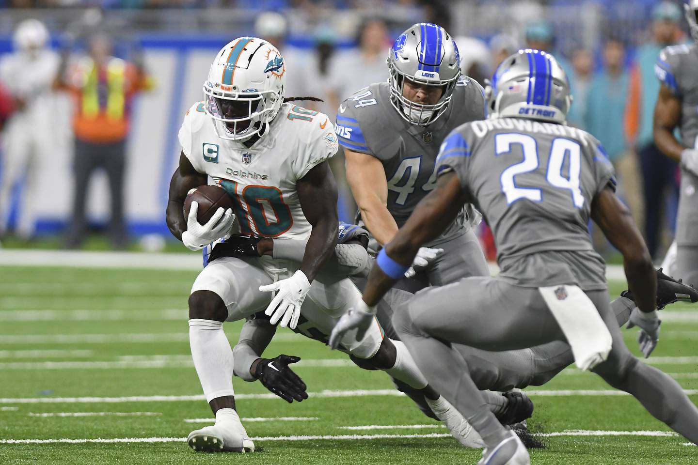 Dolphins wide receiver Tyreek Hill (10) rushes by Lions cornerback Amani Oruwariye (24) and linebacker Malcolm Rodriguez (44) during the first half Sunday, Oct. 30, 2022, in Detroit.