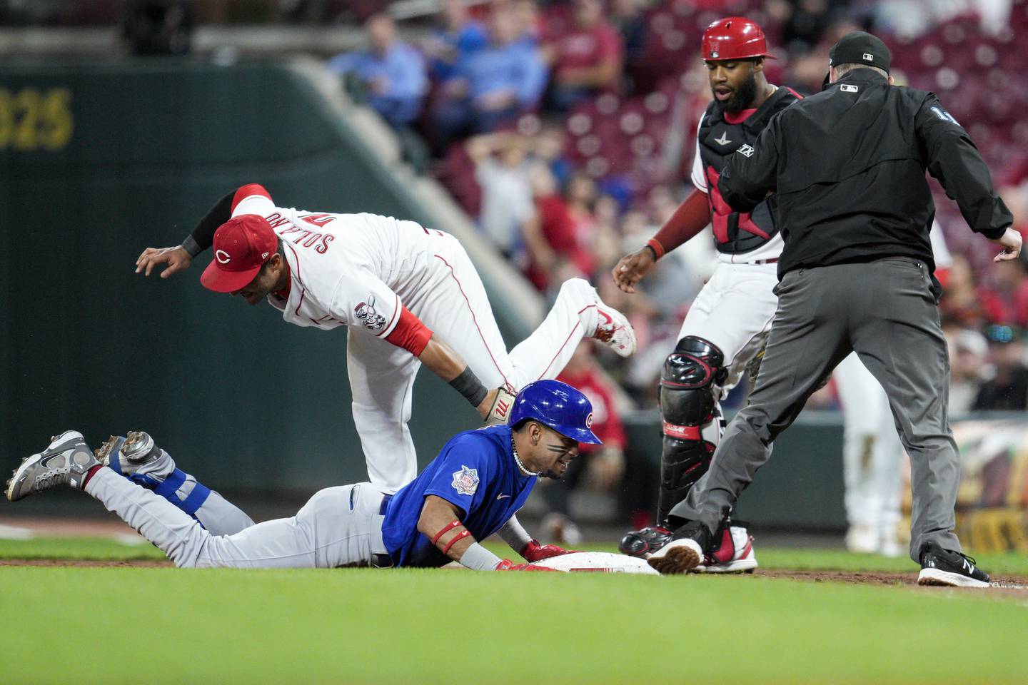 The Cubs' Christopher Morel dives back to first after reaching on a throwing error by Reds third baseman Spencer Steer during the sixth inning Tuesday, Oct. 4, 2022, in Cincinnati.