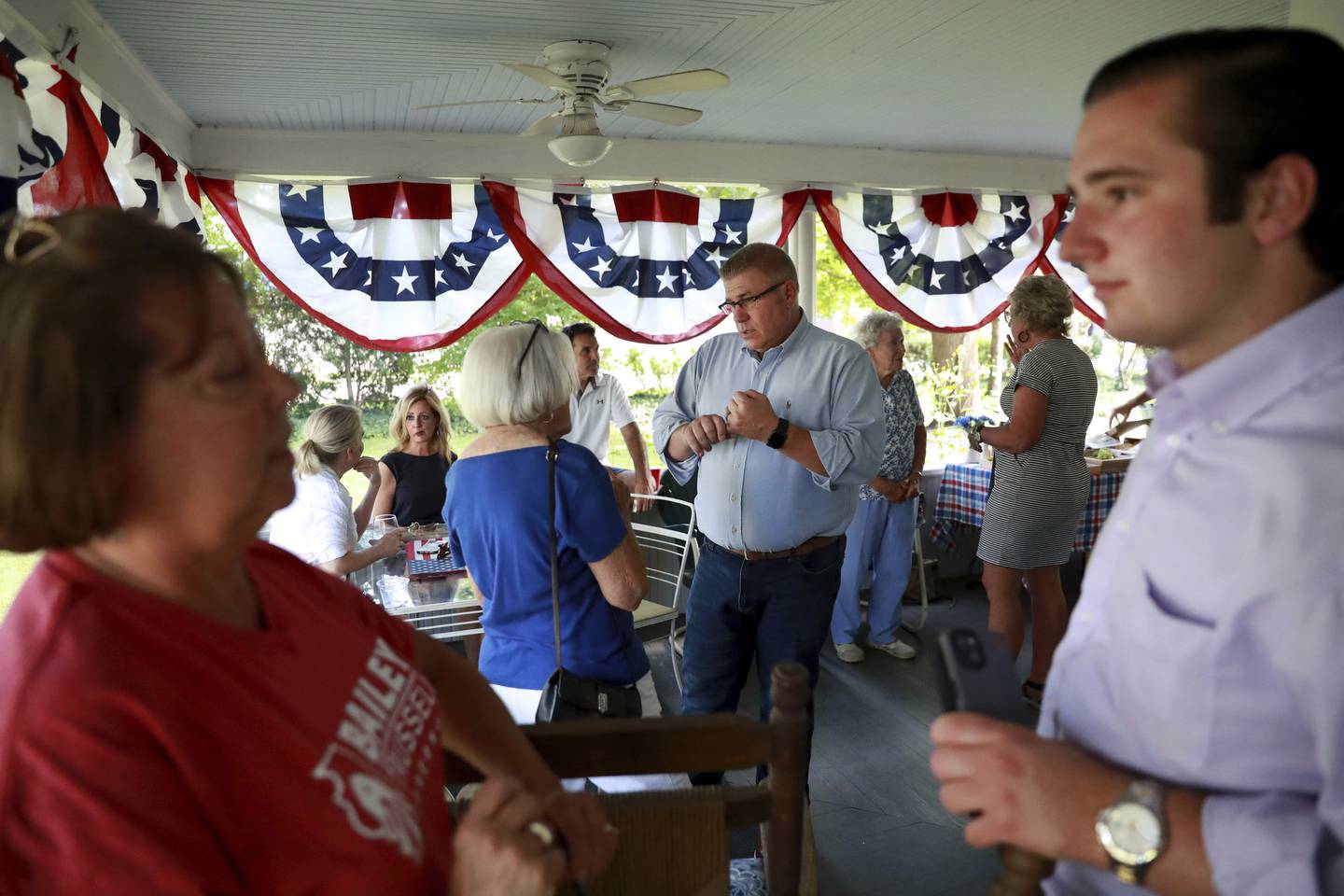 Republican nominee for governor Darren Bailey, center, talks with voters at the home of a supporter in West Dundee on July 22, 2022.