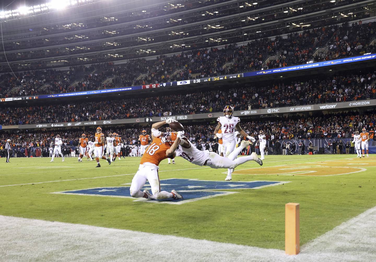 Bears wide receiver Dante Pettis (18) bends backward for an unsuccessful reception as Commanders safety Darrick Forrest defends in the end zone in the fourth quarter Thursday at Soldier Field. 