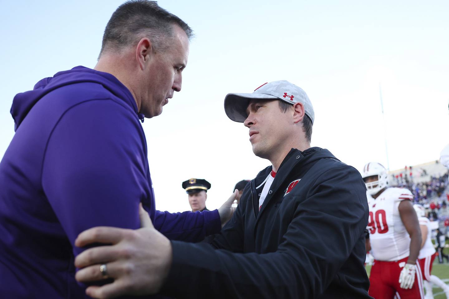 Northwestern coach Pat Fitzgerald, left, shakes hands with Wisconsin interim coach Jim Leonhard after the Badgers' 42-7 win Saturday at Ryan Field in Evanston. 