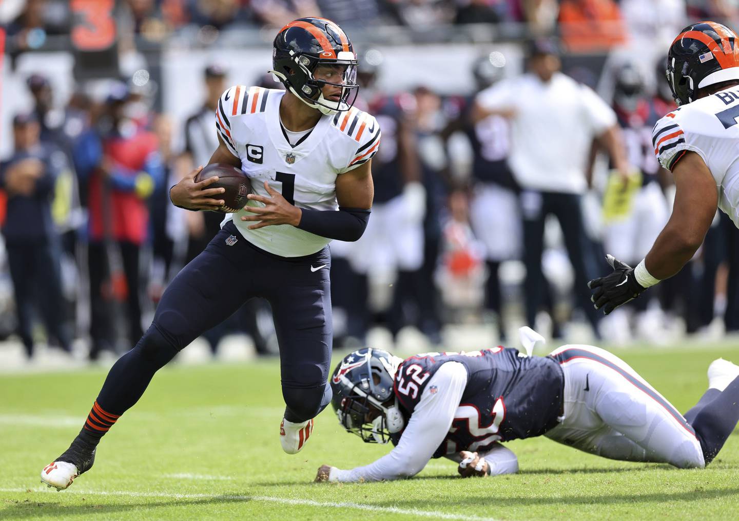 Bears quarterback Justin Fields (1) scrambles out of the pocket before running for a first down against the Texans on Sept. 25, 2022, at Soldier Field.