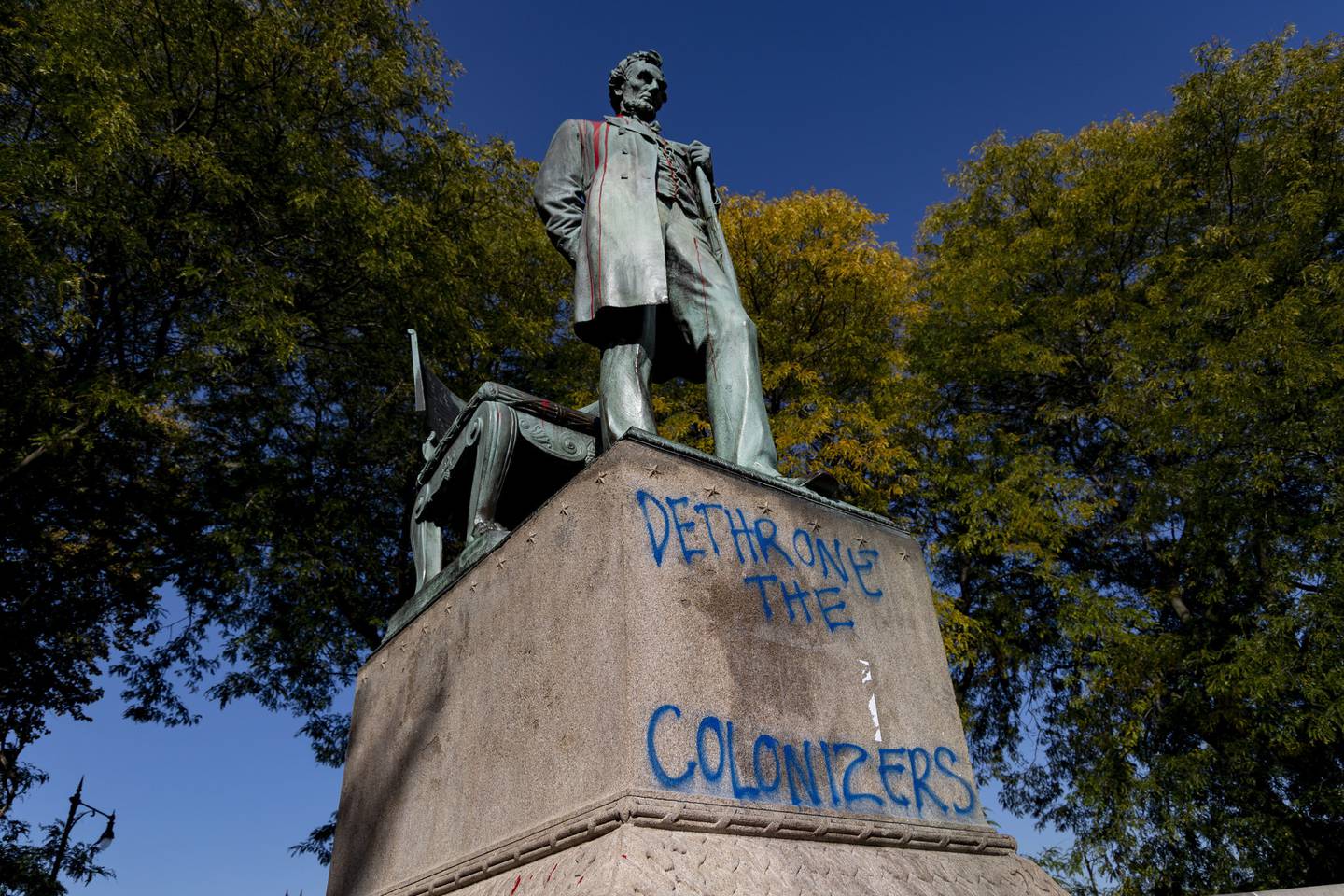 A statue of Abraham Lincoln sits vandalized on Oct. 10, 2022, on Indigenous Peoples Day behind the Chicago History Museum in Lincoln Park. 