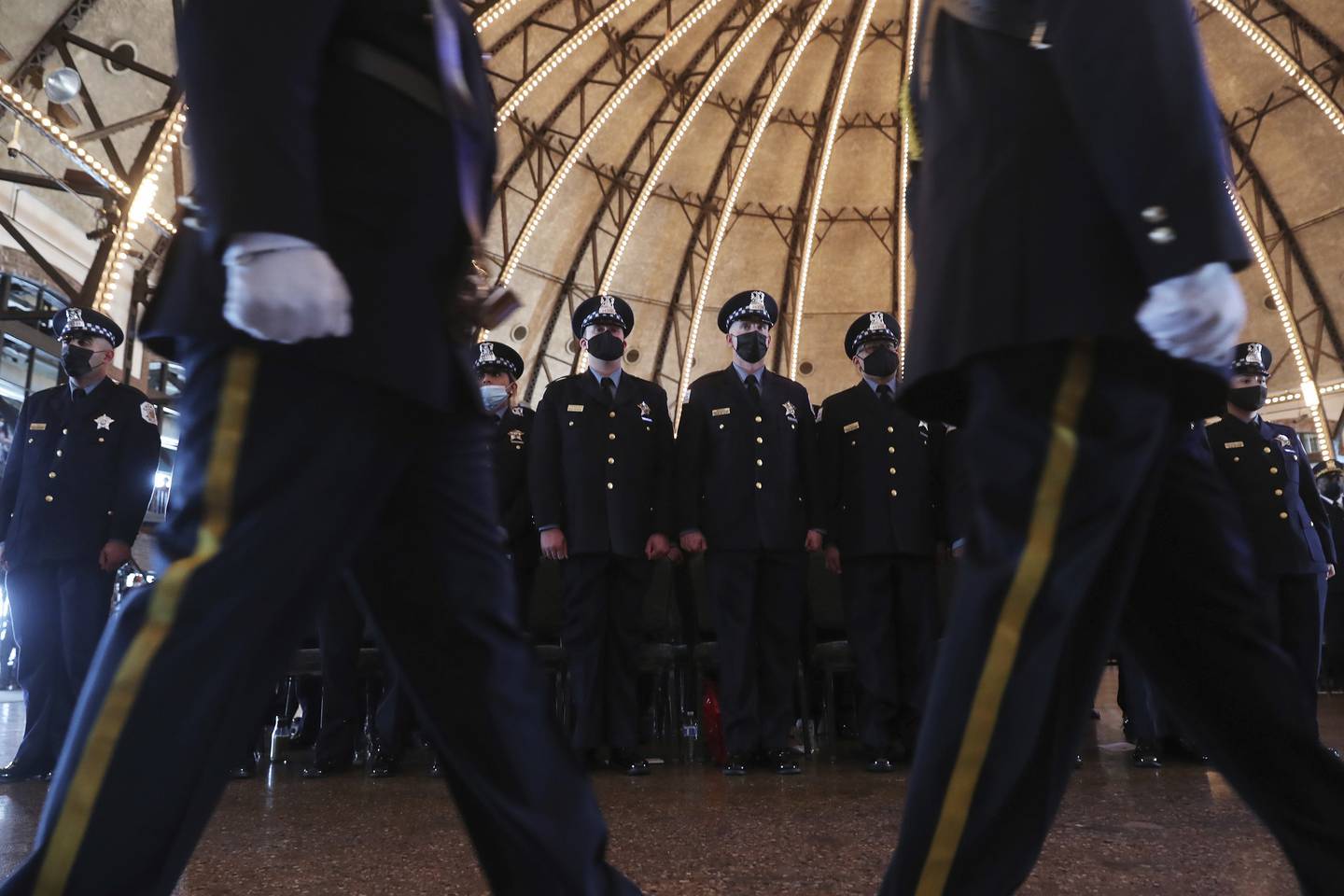 New officers stand as an honor guard marches during a Chicago Police Department graduation and promotion ceremony at Navy Pier on Oct. 20, 2021.