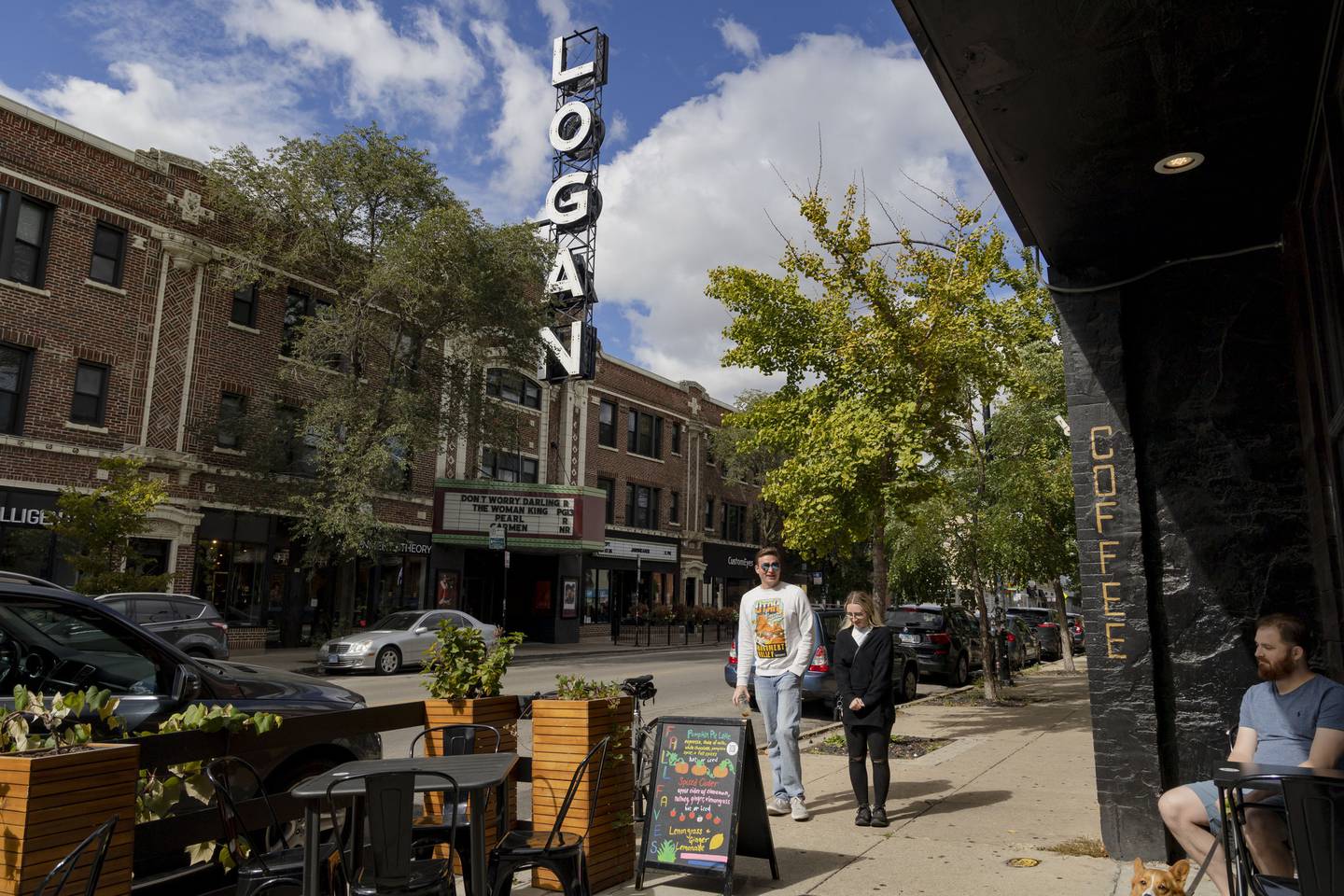 People walk by the Logan Theatre and other businesses in Logan Square on Sept. 27, 2022.