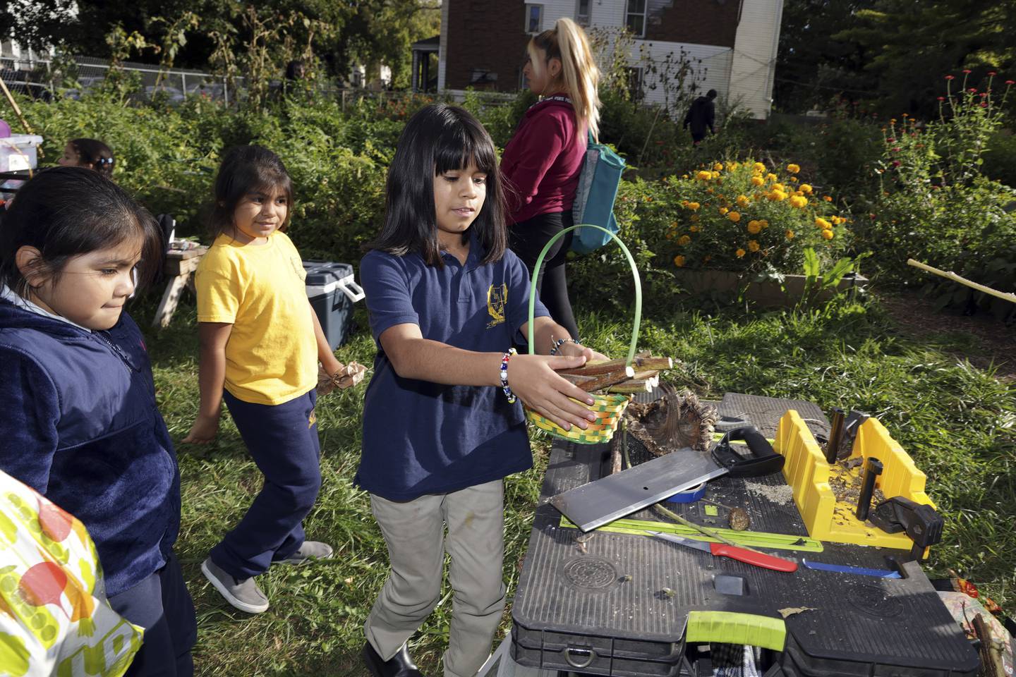 America Ortega, center, helps gather material to make pollinator nests at Star Farm on South Laflin Street in Chicago on Sept. 28, 2022. 