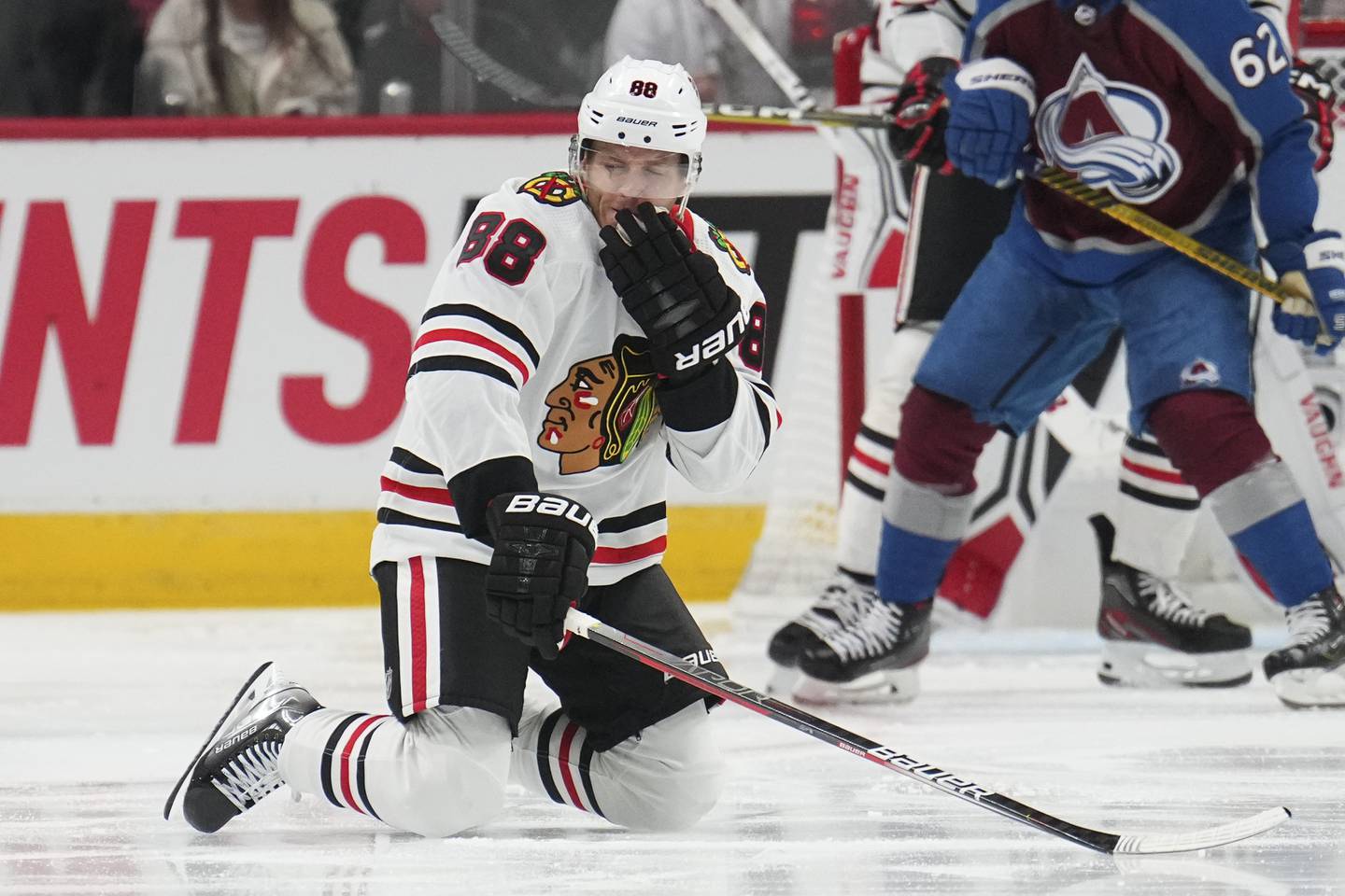 Blackhawks right wing Patrick Kane (88) reacts after getting hit in the face by a puck against the Avalanche on Oct. 12, 2022, in Denver.