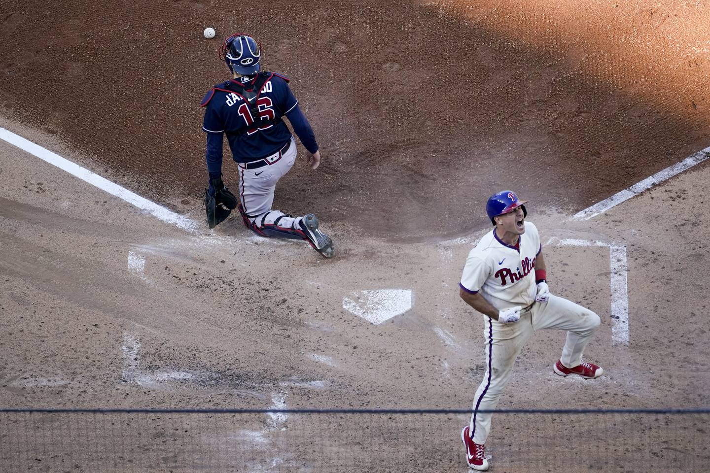 Phillies catcher J.T. Realmuto celebrates after scoring on an inside-the-park home run during the third inning of Game 4 of a National League Division Series against the Braves on Saturday in Philadelphia. 