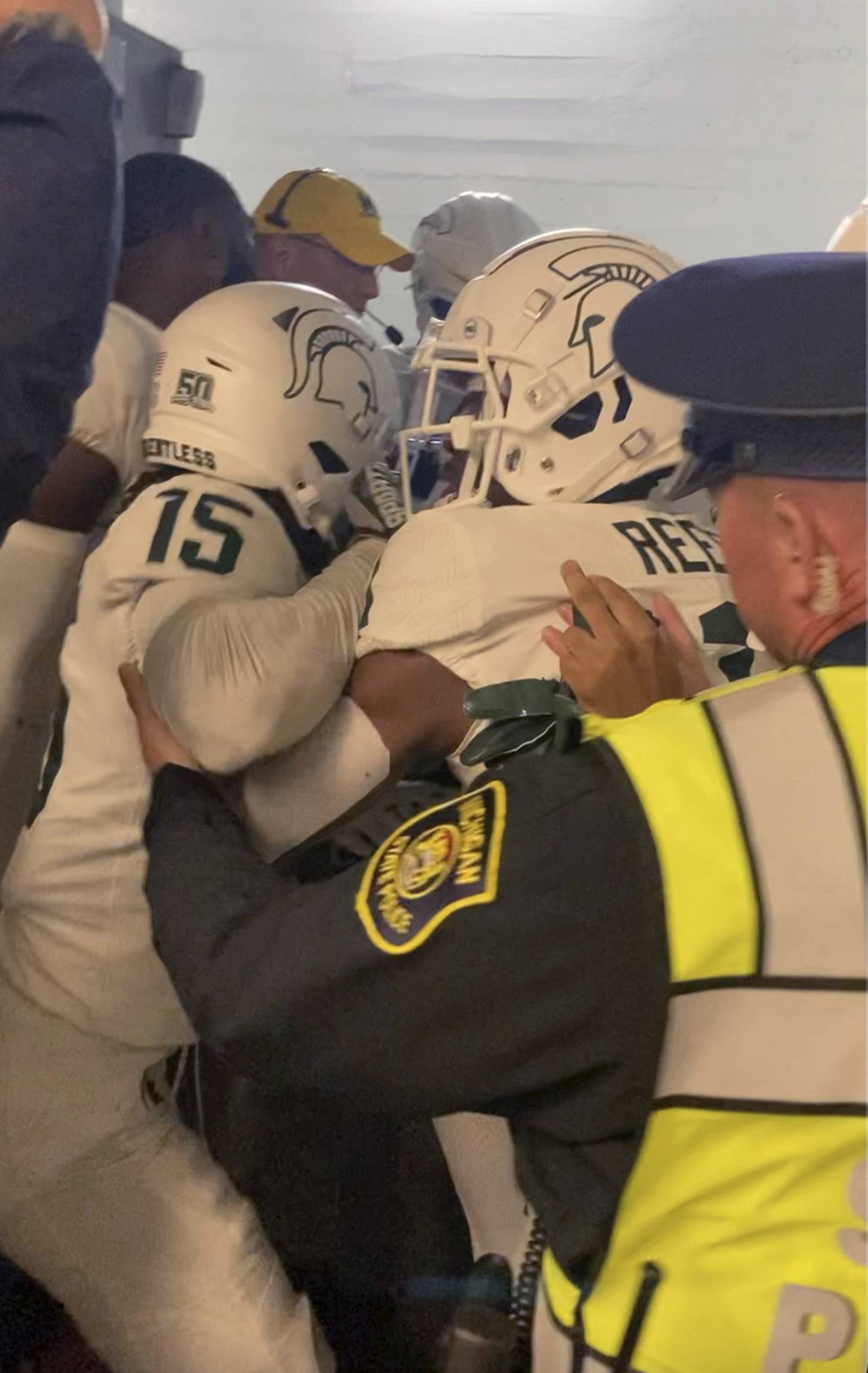 Security and police break up a scuffle between players from Michigan and Michigan State football teams a tunnel after the game on Oct. 29, 2022 in Ann Arbor, Mich.