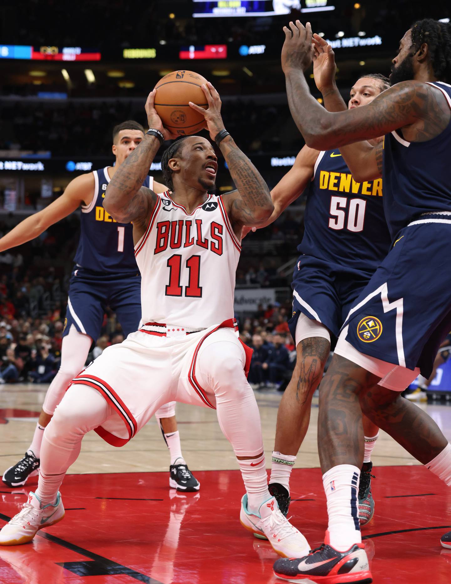 Bulls forward DeMar DeRozan (11) is surrounded by the Nuggets defenders in the first quarter of a preseason game Friday at the United Center. 