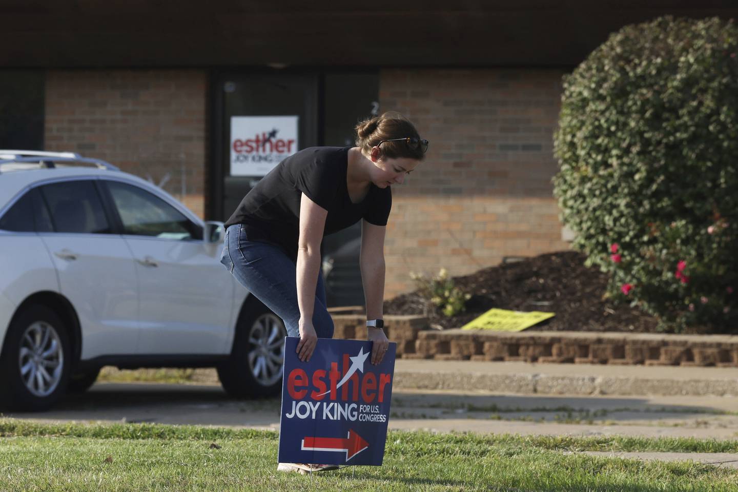 Emily Tuttle, campaign manager for 17th Congressional District Republican candidate Esther Joy King, posts a lawn sign near campaign headquarters in Moline on Sept. 15, 2022. 